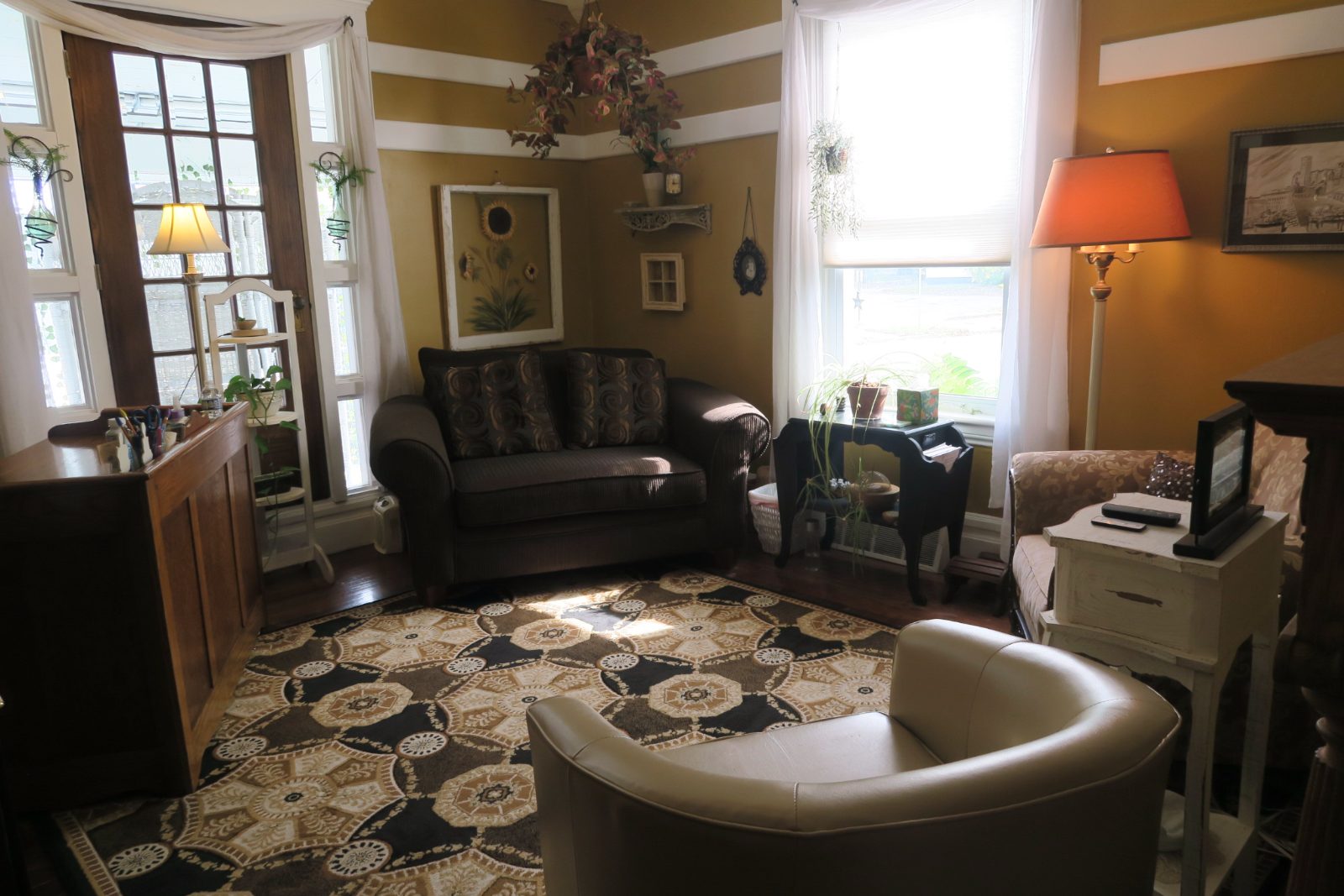 A therapy office at Lowder Psychology Group with a leather sofa, armchair and tall windows